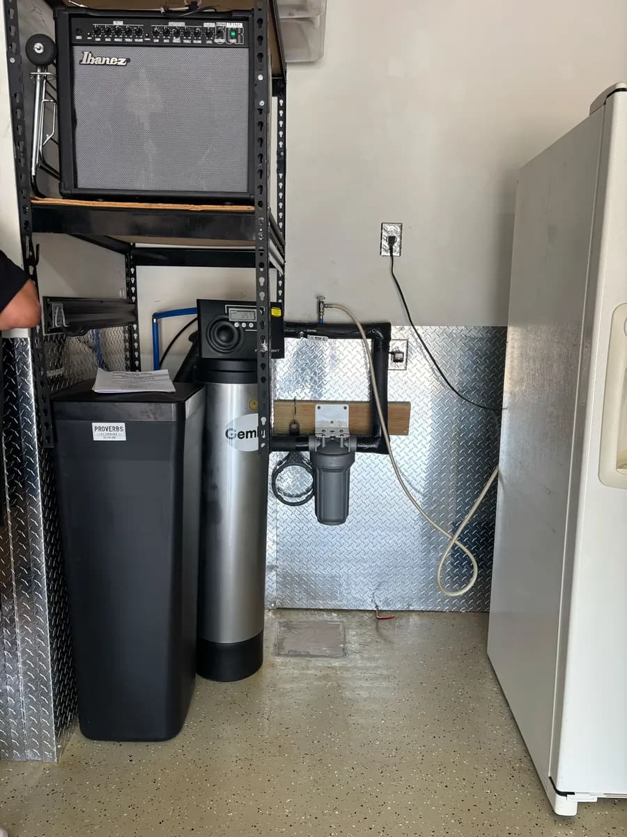 Gemline water softener, brine tank and inline sediment filter installed along a garage wall