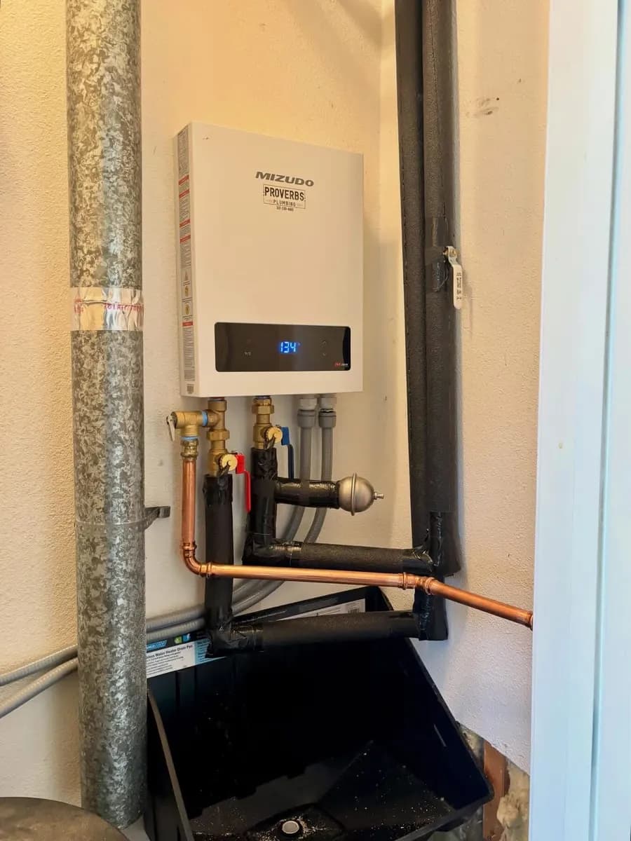 Mizudo tankless water heater running at 134 degrees on a garage wall beside the gas riser and condensate drain