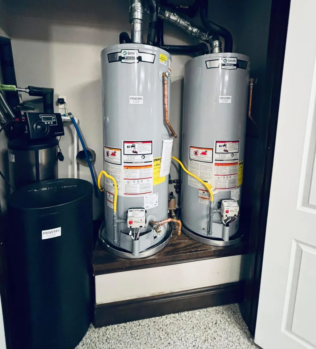 Two AO Smith ProLine gas water heaters and a FusionXT water softener installed together in a finished closet